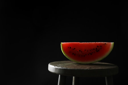 Slice of tasty fresh watermelon on table against black background, space for textの写真素材
