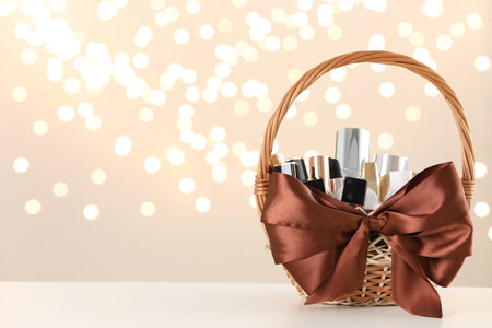 Wicker basket with cosmetics as present against blurred festive lights. Space for textの写真素材
