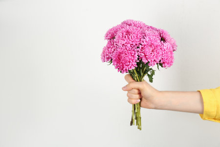 Woman with bouquet of beautiful asters and space for text on light background, closeup. Autumn flowersの写真素材