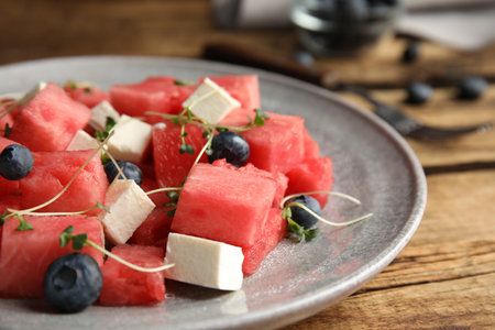 Delicious salad with watermelon, blueberries and feta cheese on wooden table, closeupの写真素材