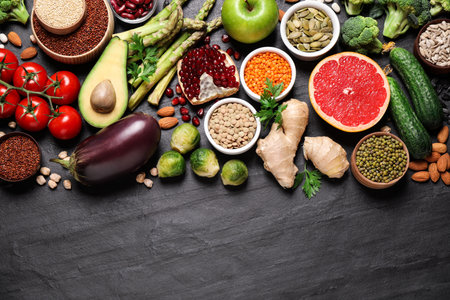 Fresh vegetables, fruits and seeds on black table, flat layの写真素材