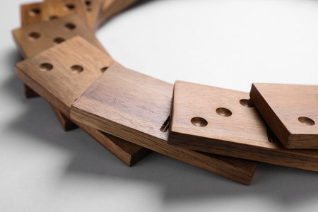 Fallen wooden domino tiles on light grey background, closeupの写真素材