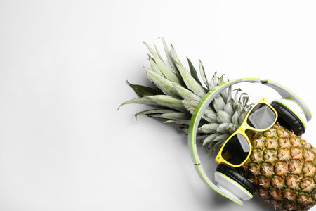 Pineapple with sunglasses and headphones on white background, top view. Creative conceptの写真素材