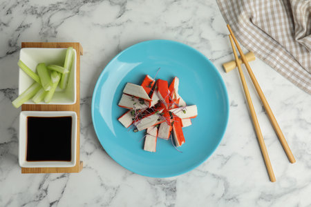 Fresh crab sticks with soy sauce and celery served on white marble table, flat layの写真素材