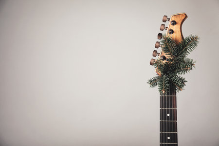 Guitar with fir tree branch on light background, space for text. Christmas musicの写真素材