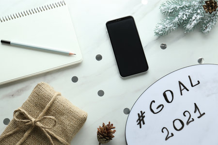 Paper card with hashtag Goal 2021, new year targets. Flat lay composition on white tableの写真素材