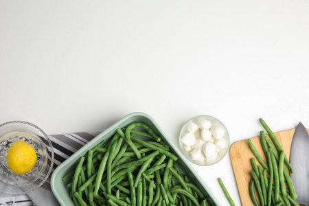 Flat lay composition with raw green beans on white table. Space for textの写真素材