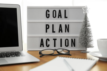 Light box with words Goal Plan Action near laptop on wooden tableの写真素材