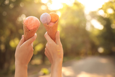 Women with ice cream spending time together outdoors, closeupの写真素材