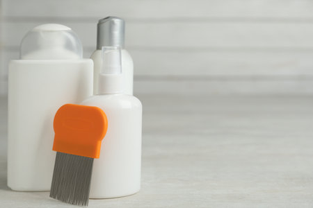 Different cosmetic products and lice comb on light table. Space for textの写真素材