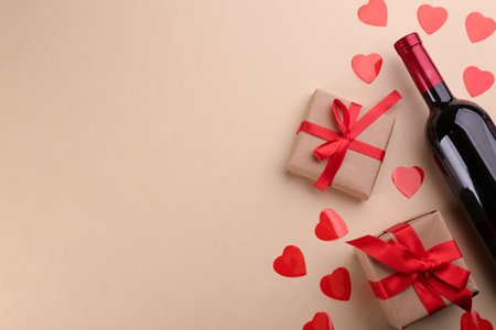 Beautiful gift box, hearts and wine on beige background, flat lay with space for text. Valentine's day celebrationの写真素材
