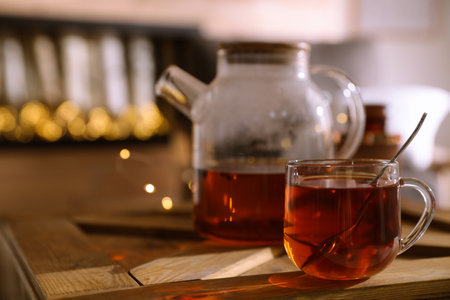 Teapot and cup with hot tea on table indoors, space for textの写真素材