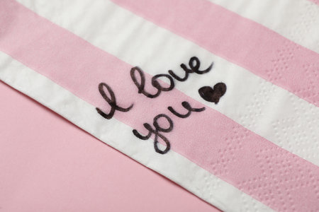 Napkin with handwritten message I Love You on pink tableの写真素材