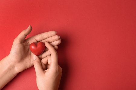Woman holding decorative heart on red background, top view with space for text. Happy Valentine's Dayの写真素材