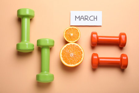 8 March greeting card design with cut citrus and dumbbells on orange background, flat lay. International Women's dayの写真素材