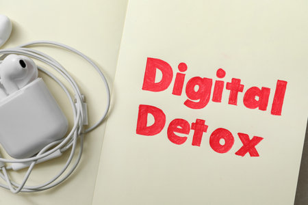 Earphones and words DIGITAL DETOX on open notebook, top viewの写真素材