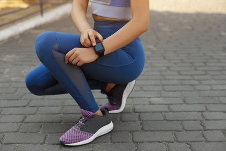 Woman using stylish smart watch during training outdoors, closeupの写真素材