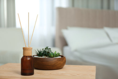 Air reed fresher and houseplants on wooden table in the bedroom. Space for textの写真素材