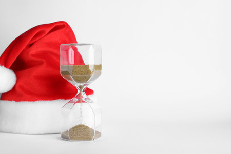 Hourglass and Santa hat on white background. christmas count down