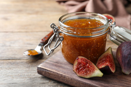 Homemade delicious fig jam and fresh fruits on wooden table, closeup. Space for textの写真素材