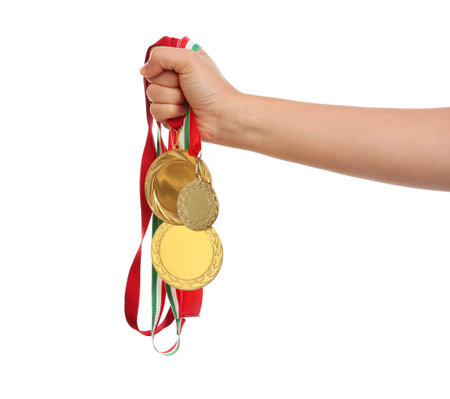 Woman holding gold medals on white background, closeupの写真素材