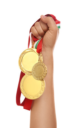 Woman holding gold medals on white background, closeupの写真素材