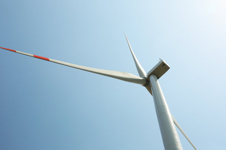 Modern wind turbine against blue sky, low angle view. energy efficiency