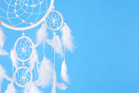 Beautiful handmade dream catcher on light blue background, closeup. Space for textの写真素材