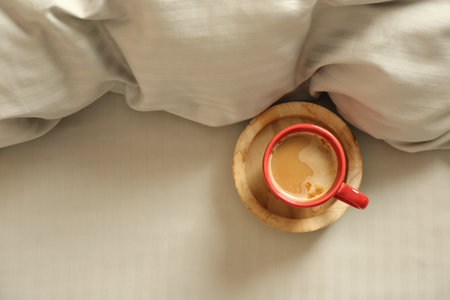Cup of aromatic coffee on bed with soft blanket, top viewの写真素材