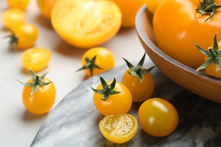 Ripe yellow tomatoes on marble board, closeupの写真素材