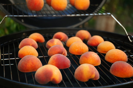 Modern grill with tasty cut peaches outdoors, closeupの写真素材