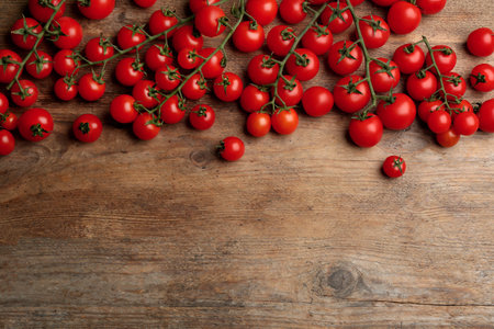 Fresh ripe cherry tomatoes on wooden table, flat lay. Space for textの写真素材