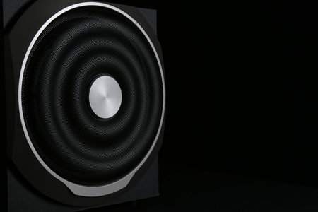 Modern subwoofer on black background, space for text. Powerful audio speakerの写真素材