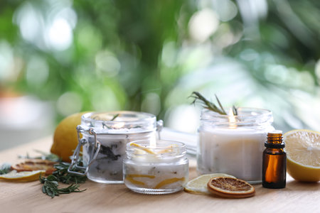 Natural homemade mosquito repellent candles and ingredients on wooden table outdoorsの写真素材