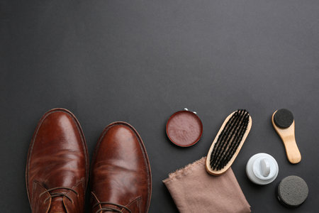 Flat lay composition with shoe care accessories and footwear on black background. Space for textの写真素材