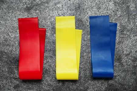 Set of fitness elastic bands on gray stone background, flat layの写真素材