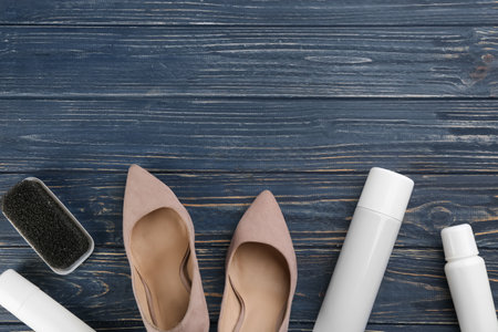 Stylish footwear with shoe care accessories on blue wooden table, flat lay. Space for textの写真素材
