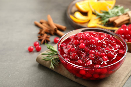Fresh cranberry sauce served in glass bowl on gray table, space for textの写真素材