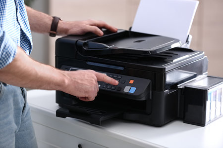 Employee using modern printer in office, closeupの写真素材