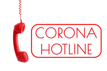 Covid-19 Hotline. Red handset and text on white backgroundの写真素材