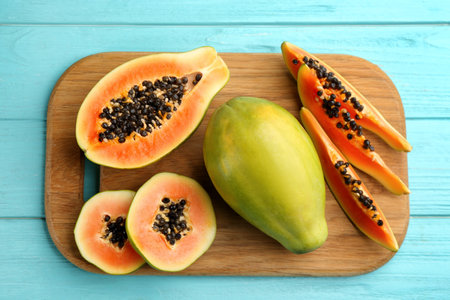 Fresh ripe papaya fruits on turquoise wooden table, flat layの写真素材