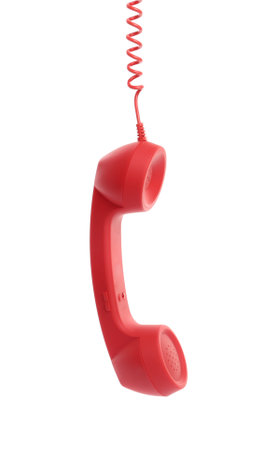 Red corded telephone handset hanging on white background. hotline conceptの写真素材