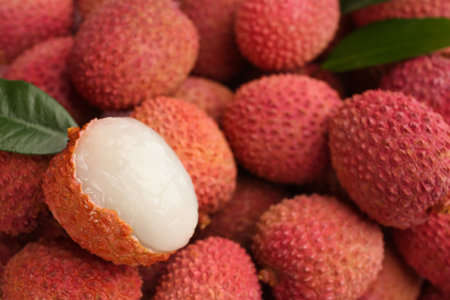Pile of fresh ripe lychees with leaves as background, closeupの写真素材