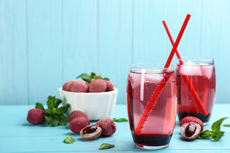 Lychee cocktail on cyan wooden table, space for textの写真素材