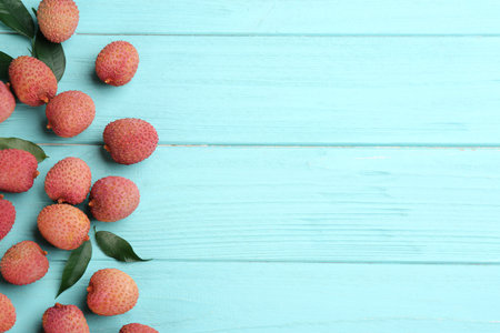 Fresh ripe lychee fruits on light blue wooden table, flat lay. Space for textの写真素材