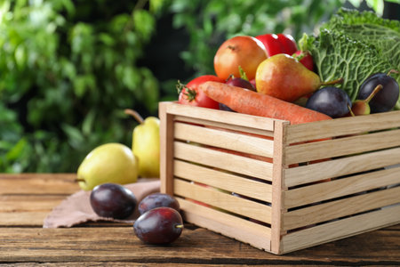 Crate full of different vegetables and fruits on wooden table outdoors, closeup. Harvesting timeの写真素材