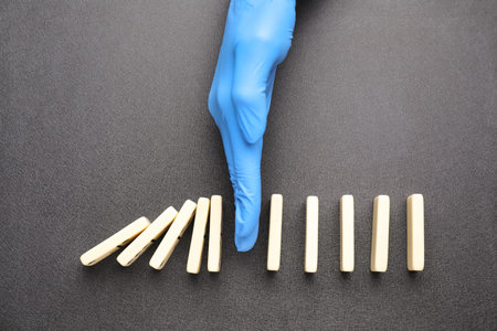 Doctor stopping domino effect on gray background, top view.の写真素材
