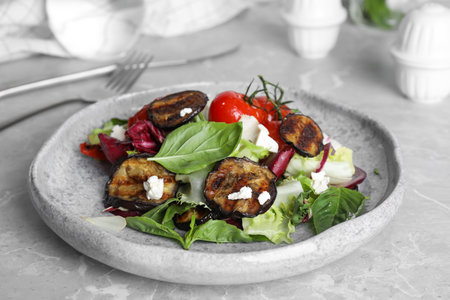 Delicious salad with roasted eggplant, basil and cheese served on gray marble tableの写真素材