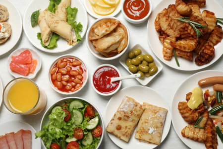 buffet service. Many different dishes on white wooden table, flat layの写真素材