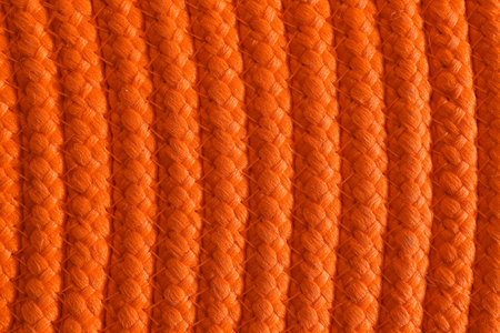 Texture of orange wicker mat as background, top view